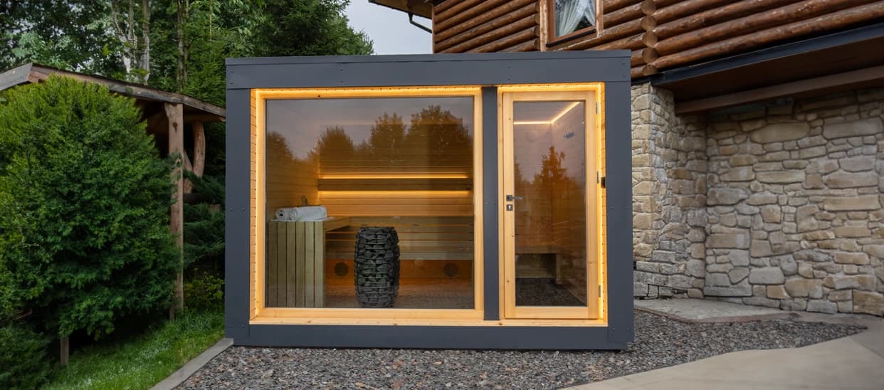 Custom-designed sauna beside the stone-and-timber guesthouse building in Zakopane